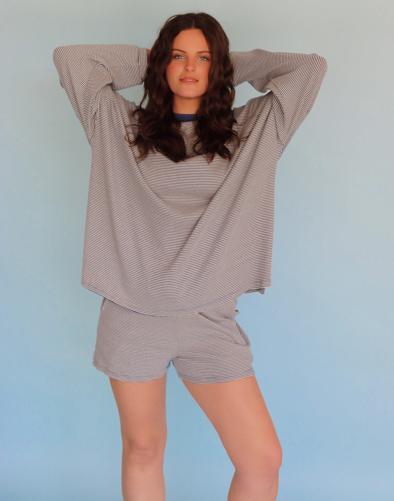 Person wearing a blue striped loungewear set against a light blue background