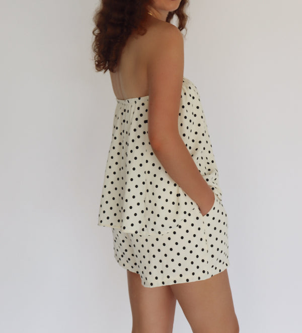 woman wearing a polka dot set against a plain background