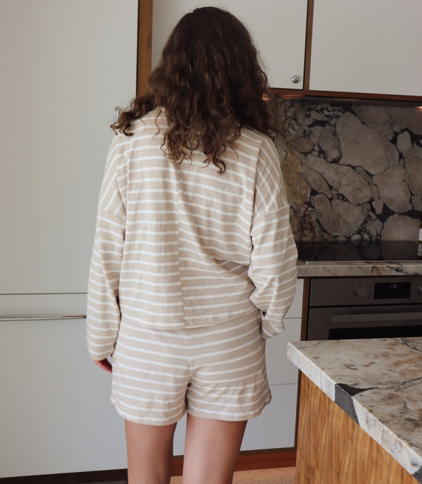 woman wearing taupe and white striped set in a kitchen setting