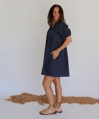 Woman in a navy dress with blue polka dots 
