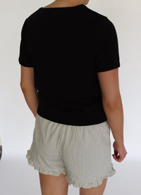 woman wearing a black tee shirt and striped shorts