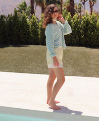 Person wearing a striped cardigan and lace shorts outdoors