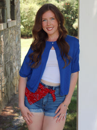 Woman in blue cardigan in an outside setting